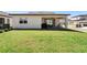 A spacious backyard with green grass, patio, a grill, and an outdoor dining area at 4911 Shady Pines Dr, St Cloud, FL 34772