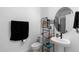 Bathroom with pedestal sink, black accents and fixtures, toilet and glass enclosed shower in the background at 4911 Shady Pines Dr, St Cloud, FL 34772
