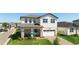 Two-story home with brick driveway and lawn at 4911 Shady Pines Dr, St Cloud, FL 34772