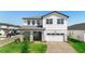 Two-story home featuring a brick driveway, an attached garage, and a well-manicured lawn at 4911 Shady Pines Dr, St Cloud, FL 34772