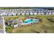 Aerial view of the community pool, pavilion, landscaping, and surrounding neighborhood with a tranquil lake at 5251 Meredrew Ln, St Cloud, FL 34771