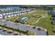 Beautiful aerial view of community pool, playground, parking, and homes with a lake in the background at 5251 Meredrew Ln, St Cloud, FL 34771
