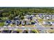 Aerial view of a modern neighborhood with tree-lined streets, a pond, and conveniently located near wooded area at 5251 Meredrew Ln, St Cloud, FL 34771