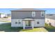 Back exterior view of the home featuring a covered patio with a small yard at 5251 Meredrew Ln, St Cloud, FL 34771