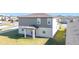Back view of a modern home with a covered patio and well-maintained backyard at 5251 Meredrew Ln, St Cloud, FL 34771