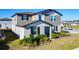 Two-story home featuring neutral siding, well-manicured front yard, and covered porch in a Gathering-friendly community at 5251 Meredrew Ln, St Cloud, FL 34771