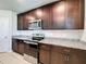 Close up of modern kitchen with dark cabinets, granite countertops, and stainless steel appliances at 5251 Meredrew Ln, St Cloud, FL 34771