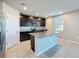 Modern kitchen featuring granite countertops, dark wood cabinets, stainless steel appliances, and a functional island at 5251 Meredrew Ln, St Cloud, FL 34771
