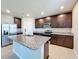 Kitchen with a large island with a sink, stainless steel appliances, and dark wood cabinetry at 5251 Meredrew Ln, St Cloud, FL 34771