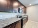 Kitchen with dark cabinets, stainless steel appliances, and granite countertops, showcasing modern design at 5251 Meredrew Ln, St Cloud, FL 34771