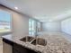 Kitchen sink on an island with granite countertops, offering a view of the living room and backyard at 5251 Meredrew Ln, St Cloud, FL 34771