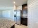Kitchen with stainless steel refrigerator and granite countertops next to a pantry door at 5251 Meredrew Ln, St Cloud, FL 34771