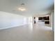 Open-concept living room featuring tile floors seamlessly connecting to a kitchen with dark wood cabinets at 5251 Meredrew Ln, St Cloud, FL 34771