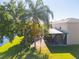 View of backyard of home including screen enclosed porch and partial lake view at 543 Flower Fields Ln, Orlando, FL 32824