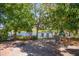 Brick backyard patio surrounded by mature trees and lush landscaping overlooking the tranquil lake at 543 Flower Fields Ln, Orlando, FL 32824