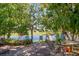 Brick backyard patio surrounded by mature trees and lush landscaping overlooking the tranquil lake at 543 Flower Fields Ln, Orlando, FL 32824