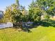 Landscaped backyard with mature trees, green grass and outdoor seating, perfect for relaxing at 543 Flower Fields Ln, Orlando, FL 32824