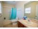 Bathroom featuring a shower-tub combo with blue curtain, a toilet, and a vanity with an oval sink at 543 Flower Fields Ln, Orlando, FL 32824