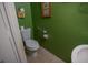 Small half-bath with tile flooring, sink, toilet, grab-bar and decorated with lovely artwork at 543 Flower Fields Ln, Orlando, FL 32824