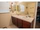 Bathroom with double sinks set into a dark wood vanity and a large mirror at 543 Flower Fields Ln, Orlando, FL 32824