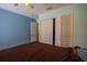 Bedroom featuring bi-fold closet doors, light blue walls and a ceiling fan at 543 Flower Fields Ln, Orlando, FL 32824