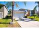 Home exterior with attached garage, manicured lawn and tropical palm trees at 543 Flower Fields Ln, Orlando, FL 32824