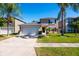Home exterior featuring attached garage, neatly landscaped front yard and palm trees at 543 Flower Fields Ln, Orlando, FL 32824