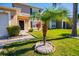 Charming front yard with lush grass, tropical plants, and stone-lined walkway leading to the entrance at 543 Flower Fields Ln, Orlando, FL 32824