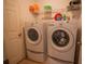 Laundry room featuring a washer and dryer, with shelving above for storage space at 543 Flower Fields Ln, Orlando, FL 32824