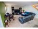 Comfortable living room featuring a large black sectional, shelving units, and green accent wall at 543 Flower Fields Ln, Orlando, FL 32824