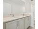 Bathroom featuring a double sink vanity with modern faucets, a large mirror, and neutral cabinets at 5717 Haystack Dr, St Cloud, FL 34771