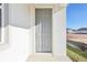 Inviting gray front door with sidelight panel, set in a bright white facade at 5717 Haystack Dr, St Cloud, FL 34771