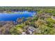 Stunning aerial view of lakefront home surrounded by mature trees and lush landscaping at 5824 N Dean Rd, Orlando, FL 32817