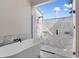 Modern bathroom featuring a luxurious soaking tub and a spacious glass-enclosed shower with marble tile at 5824 N Dean Rd, Orlando, FL 32817