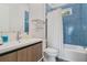 Blue bathroom with a wood vanity, modern sink, a matching mirror and a bathtub at 5824 N Dean Rd, Orlando, FL 32817
