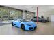Stylish garage showcasing a blue Lamborghini and grey Tesla, with glass doors and natural lighting at 5824 N Dean Rd, Orlando, FL 32817