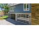A blue house boasts a garage with glass panel doors and a paved driveway at 5824 N Dean Rd, Orlando, FL 32817