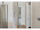 Hallway with modern wood floors, white trim, doors and cabinetry, and stainless steel refrigerator at 5824 N Dean Rd, Orlando, FL 32817
