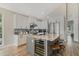 Bright kitchen features white cabinetry, stainless appliances, wine fridge and a large island with counter seating at 5824 N Dean Rd, Orlando, FL 32817