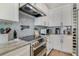 Close up on kitchen with stainless steel oven, stove and hood, and tile backsplash at 5824 N Dean Rd, Orlando, FL 32817