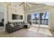 Open-concept living room with wood floors, a leather sofa, and a sliding door to the deck and waterfront at 5824 N Dean Rd, Orlando, FL 32817