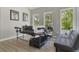 Home office with hardwood floors, a gray sofa and large windows overlooking the trees at 5824 N Dean Rd, Orlando, FL 32817
