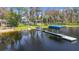 Lakefront property featuring a private dock, lush landscaping, and serene waterfront views at 5824 N Dean Rd, Orlando, FL 32817
