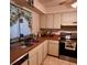 Functional kitchen with tile flooring, stainless steel oven, and white cabinetry at 604 Tradewinds Dr, Deltona, FL 32738