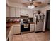 Bright kitchen with tile floor, updated stainless steel appliances, and fan with overhead lighting at 604 Tradewinds Dr, Deltona, FL 32738