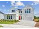 Stunning two-story white farmhouse with a paver driveway, red front door, and lush landscaping at 6244 Trailblaze Bnd, St Cloud, FL 34771