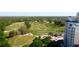 Breathtaking aerial view of a lush golf course community, complemented by residential buildings and mature trees at 7593 Gathering Dr # 203, Reunion, FL 34747