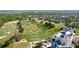 Expansive aerial shot of a meticulously maintained golf course, surrounded by lush trees and a grand residential building at 7593 Gathering Dr # 203, Reunion, FL 34747