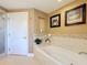 Bright bathroom showcasing a soaking tub, tiled accents, and elegant wallpaper at 7593 Gathering Dr # 203, Reunion, FL 34747