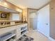 Bathroom features a double sink vanity, granite counters, a tiled shower, and a decorative mirror at 7593 Gathering Dr # 203, Reunion, FL 34747